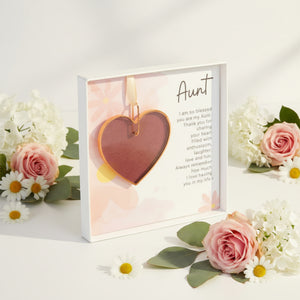 3 of 6:Pink rose mauve glass heart with Aunt sentiment in a white box with clear lid with a white background surrounded by flowers.