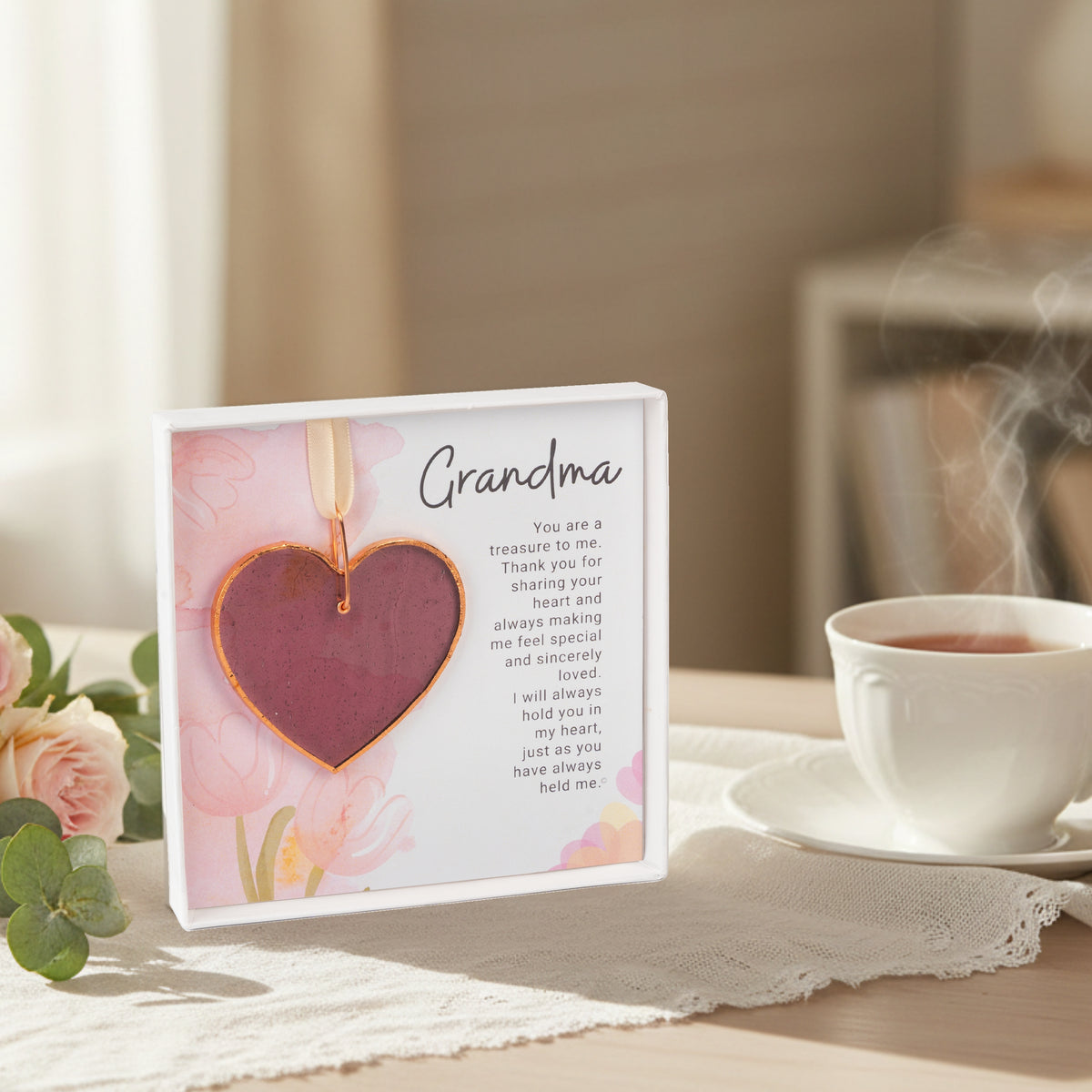Grandma gift sitting on a kitchen table next to some flowers and a tea cup.