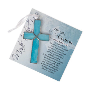 2 of 4:Light blue stained glass cross lying on the