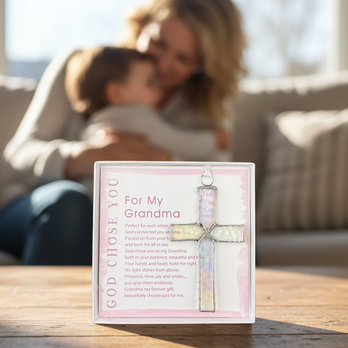 "For You Grandma" gift on a table with a grandma snuggling her grandchild in the background.