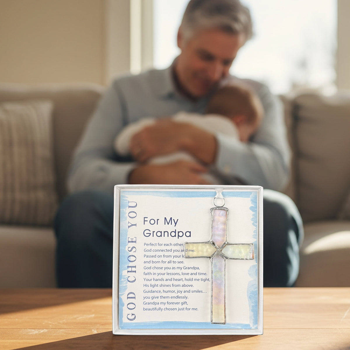 "God Chose You for My Grandpa" gift on a table in front of a grandfather holding his grandchild.