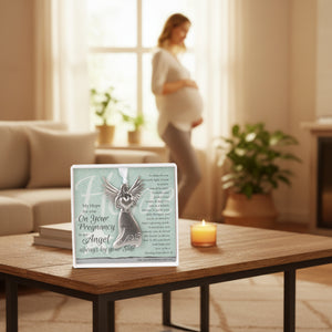 3 of 4:Gift sitting on a living room table with a pregnant woman in the background.