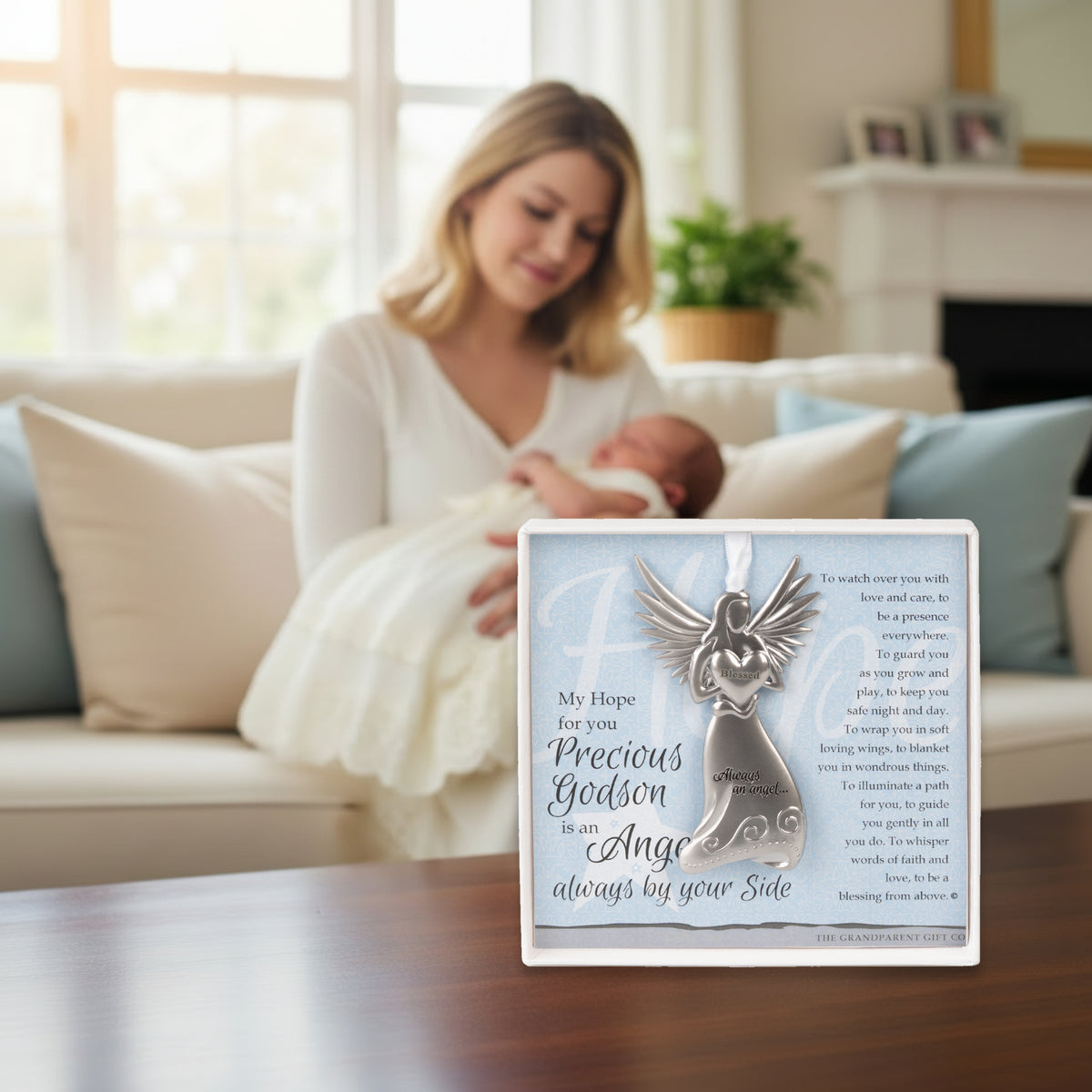 Gift displayed on a table with a godmother holding her godson in the back.