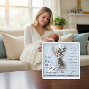 2 of 4:Gift displayed on a table with a godmother holding her godson in the back.