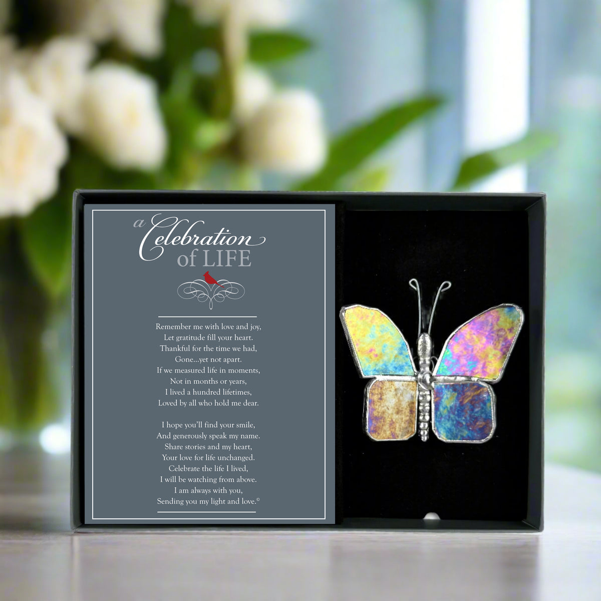 Clear iridescent butterfly in a gray box with a 'Celebration of Life' card.