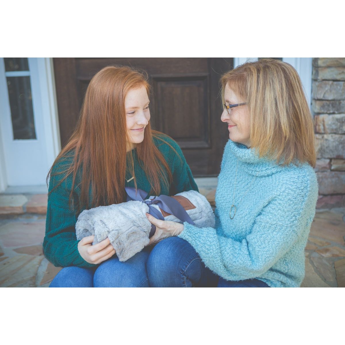 Daughter giving blanket to her mother.