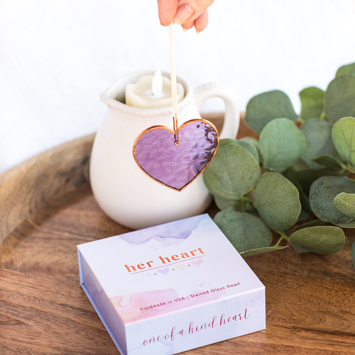 Purple stained glass heart with light shining through to show how different angles alter the color of the glass.