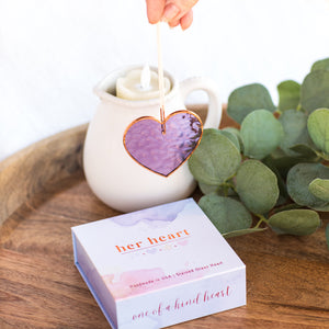 7 of 8:Purple stained glass heart with light shining through to show how different angles alter the color of the glass.