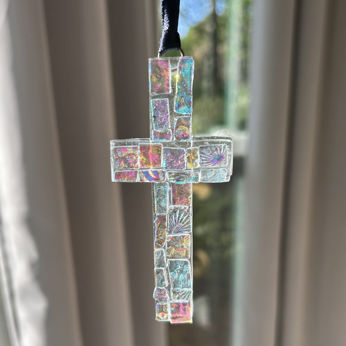 Dichroic glass cross with black satin ribbon for hanging.