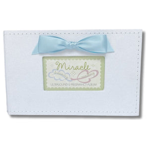 3 of 8:White faux suede photo album with blue satin bow and a window with Miracle sentiment artwork showing.