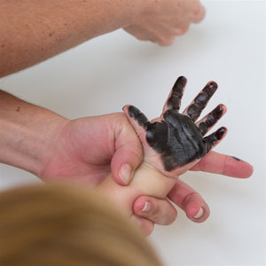 7 of 9:Child's hand covered with ink.