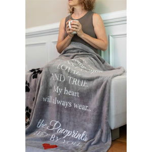 4 of 9:Pawprints Left by You blanket laid over the lap of the recipient.