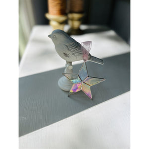9 of 10:Star leaning against an object on a desk.