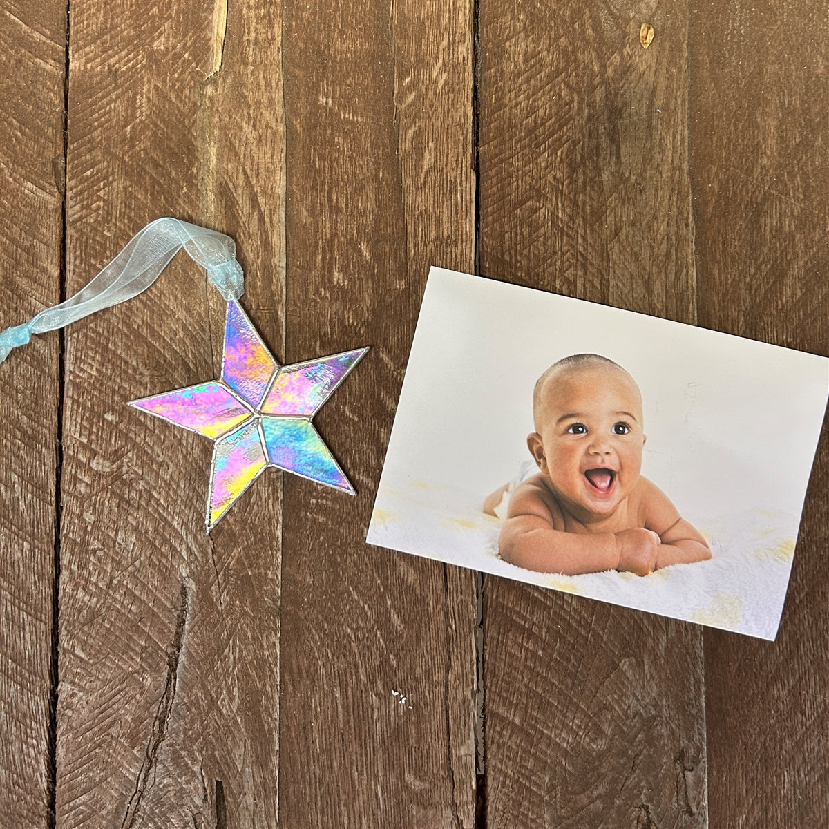 Clear iridescent star with blue organza ribbon for hanging.