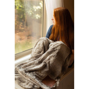 8 of 8:A woman wrapped up in the Here for You blanket.