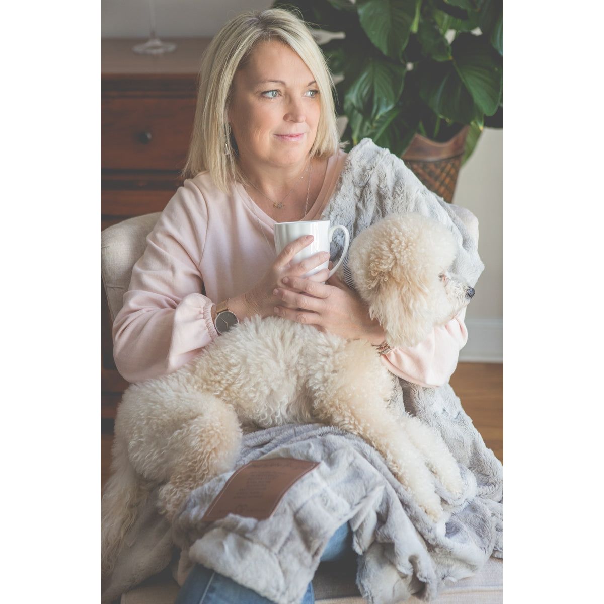 A woman snuggled in the sympathy blanket with her dog.