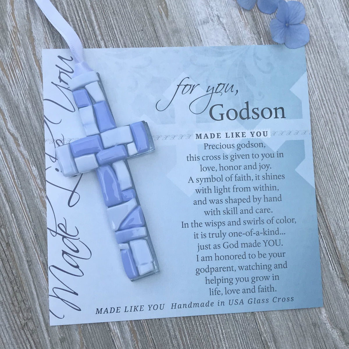 Blue Mosaic cross with shades of blue and white glass lying on the For You, Godson sentiment artwork.