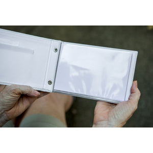 5 of 7:Brag book being held open showing the photo pockets and inside of the front cover.