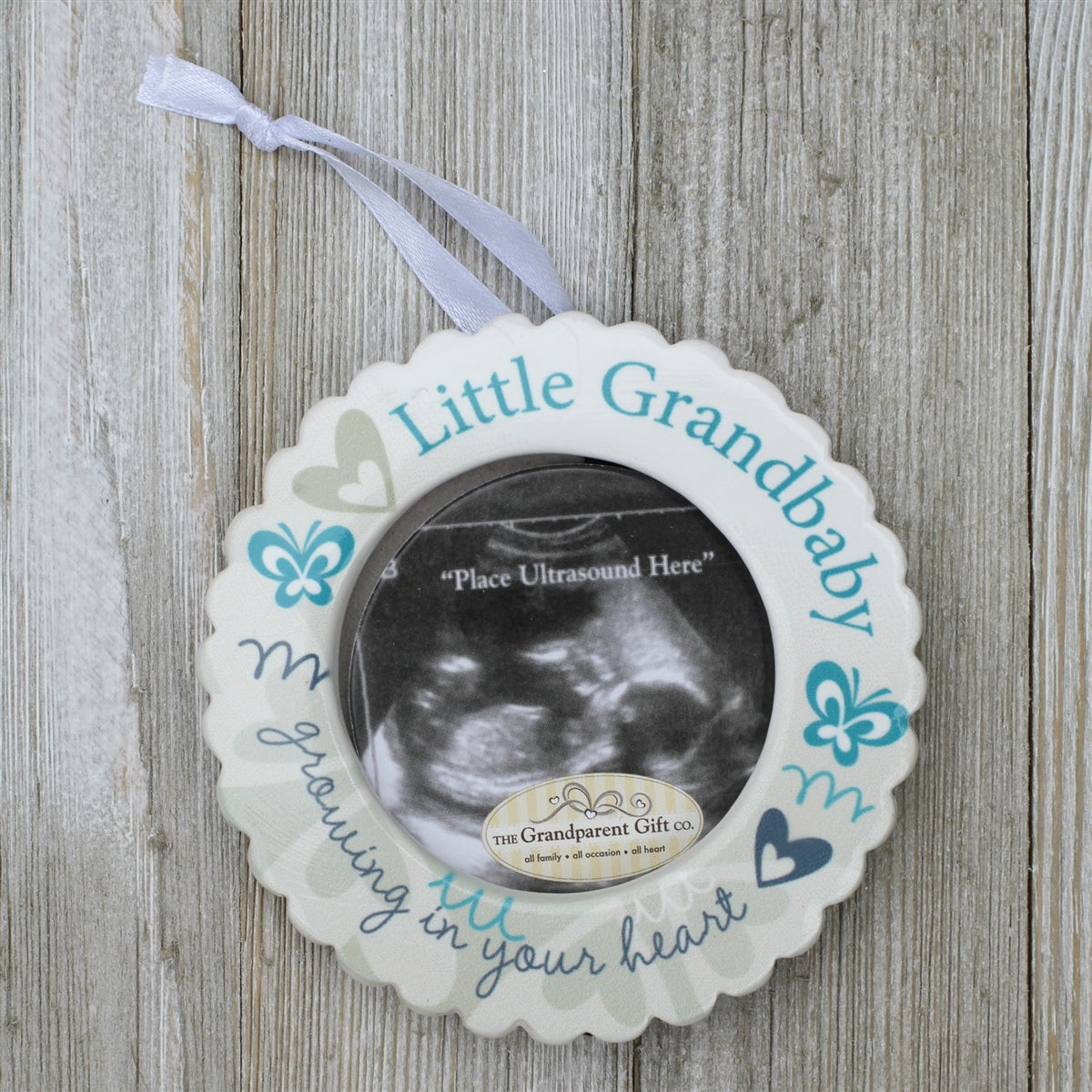 Little Grandbaby ceramic ornament with white satin ribbon for hanging.