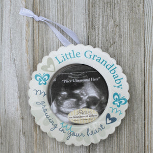 3 of 4:Little Grandbaby ceramic ornament with white satin ribbon for hanging.
