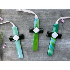 5 of 5:An assortment of green glass crosses with swirls of green and blue.