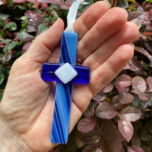 4 of 6:Blue glass cross being held in a hand.