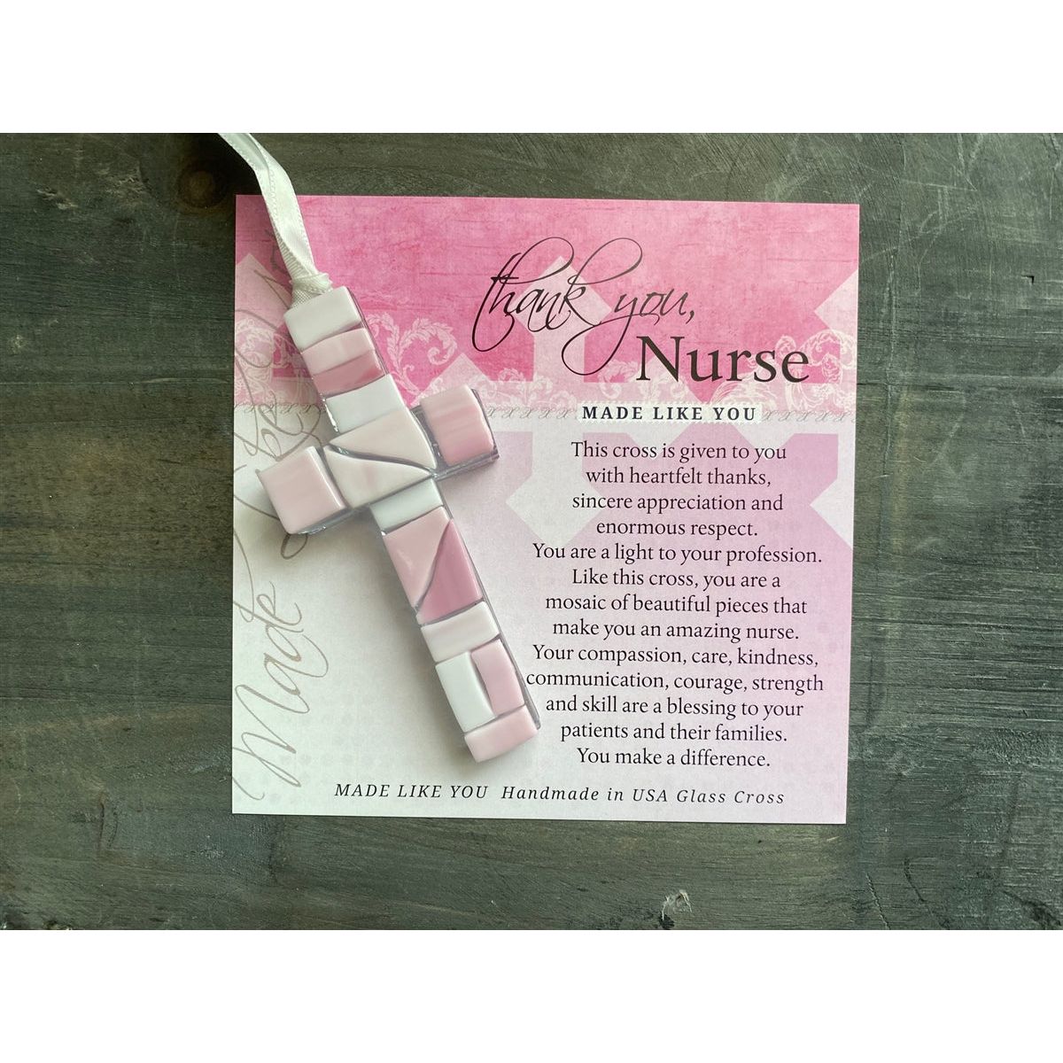 Pink Mosaic cross with shades of pink and clear glass lying on the Thank You, Nurse sentiment artwork.