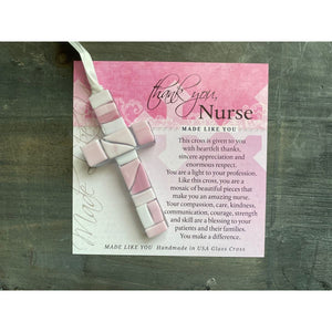 2 of 4:Pink Mosaic cross with shades of pink and clear glass lying on the Thank You, Nurse sentiment artwork.