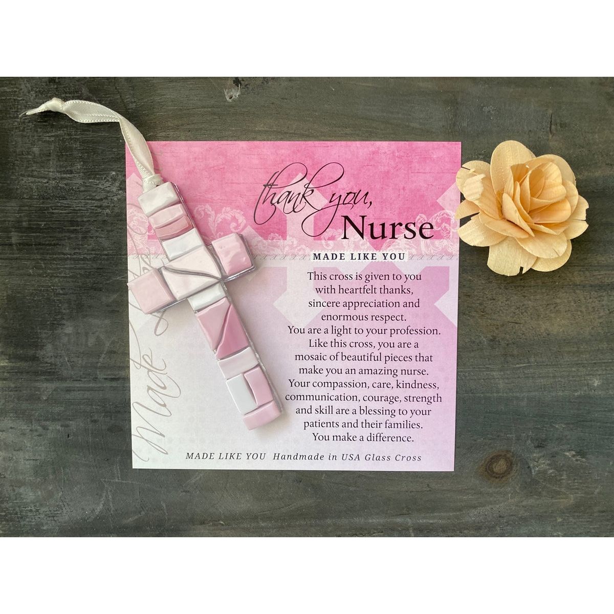 Pink Mosaic cross with shades of pink and clear glass lying on the Thank You, Nurse sentiment artwork.