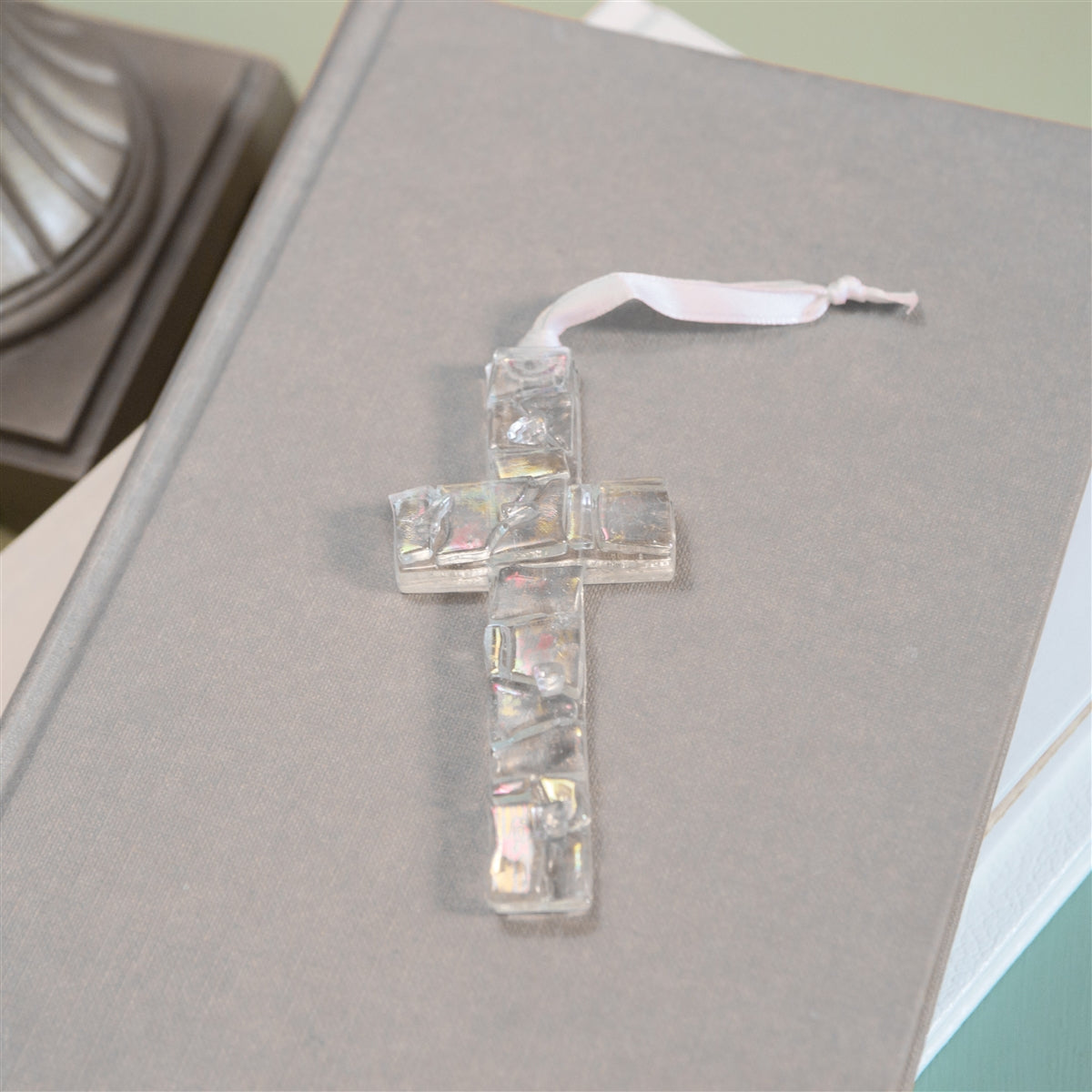 Iridescent clear mosaic cross with white satin ribbon for hanging.