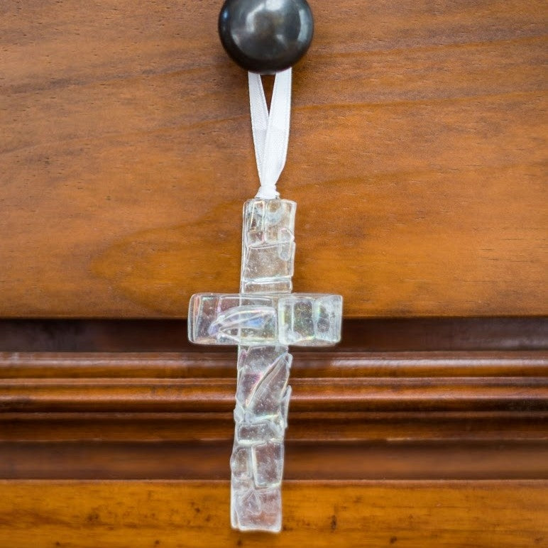 Iridescent clear mosaic cross hanging from a drawer knob.