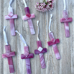 3 of 6:An assortment of pink glass crosses, each one is unique.