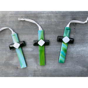 3 of 5:An assortment of green glass crosses with swirls of green and blue.