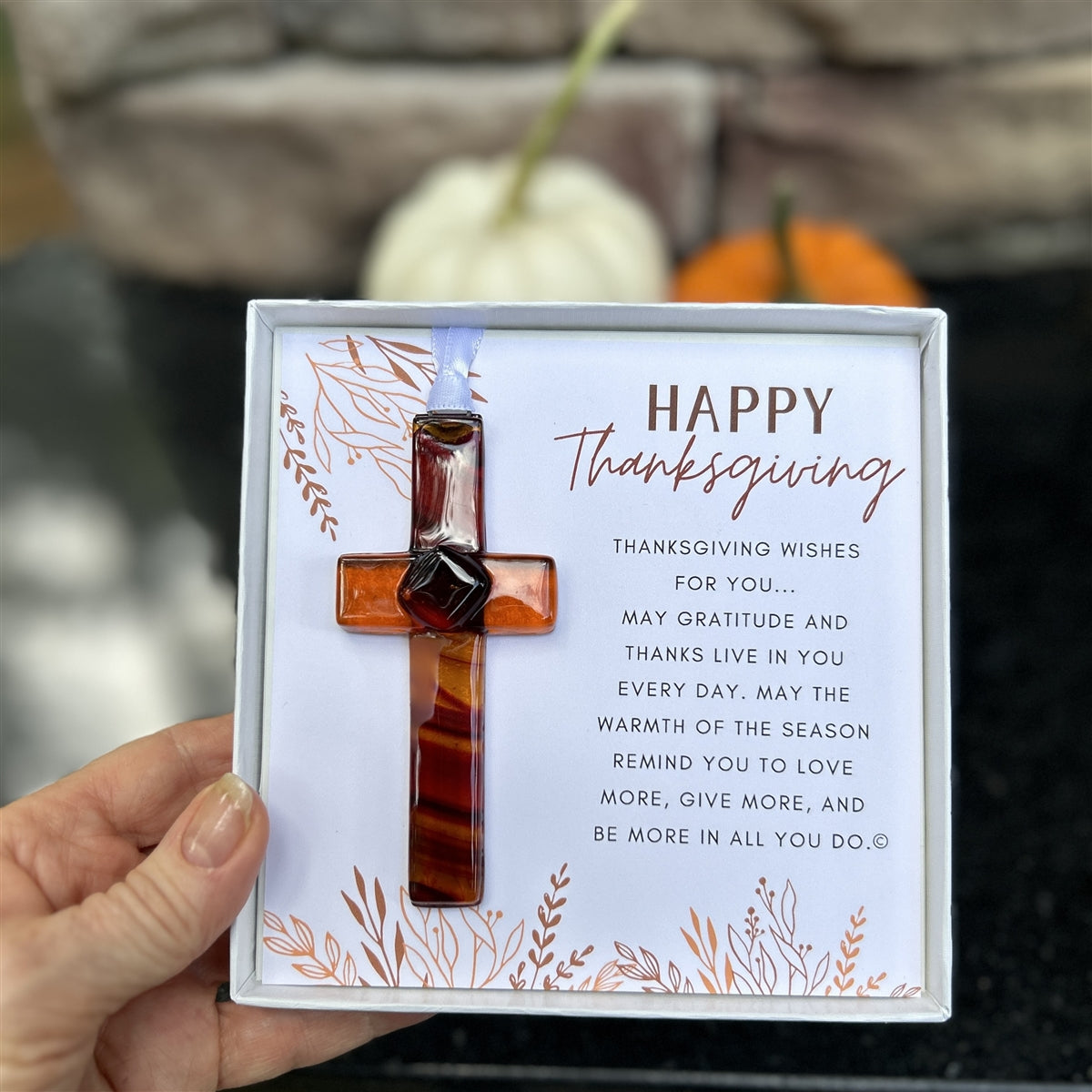 Happy Thanksgiving cross gift being held in a hand.