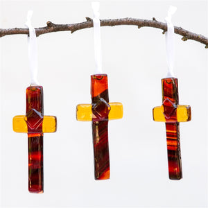 7 of 7:Three amber/brown glass crosses hanging from a branch.