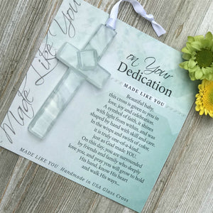 3 of 5:Clear glass cross with swirls of white lying on the