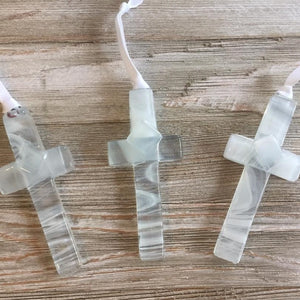 5 of 5:An assortment of clear glass crosses with white swirls.