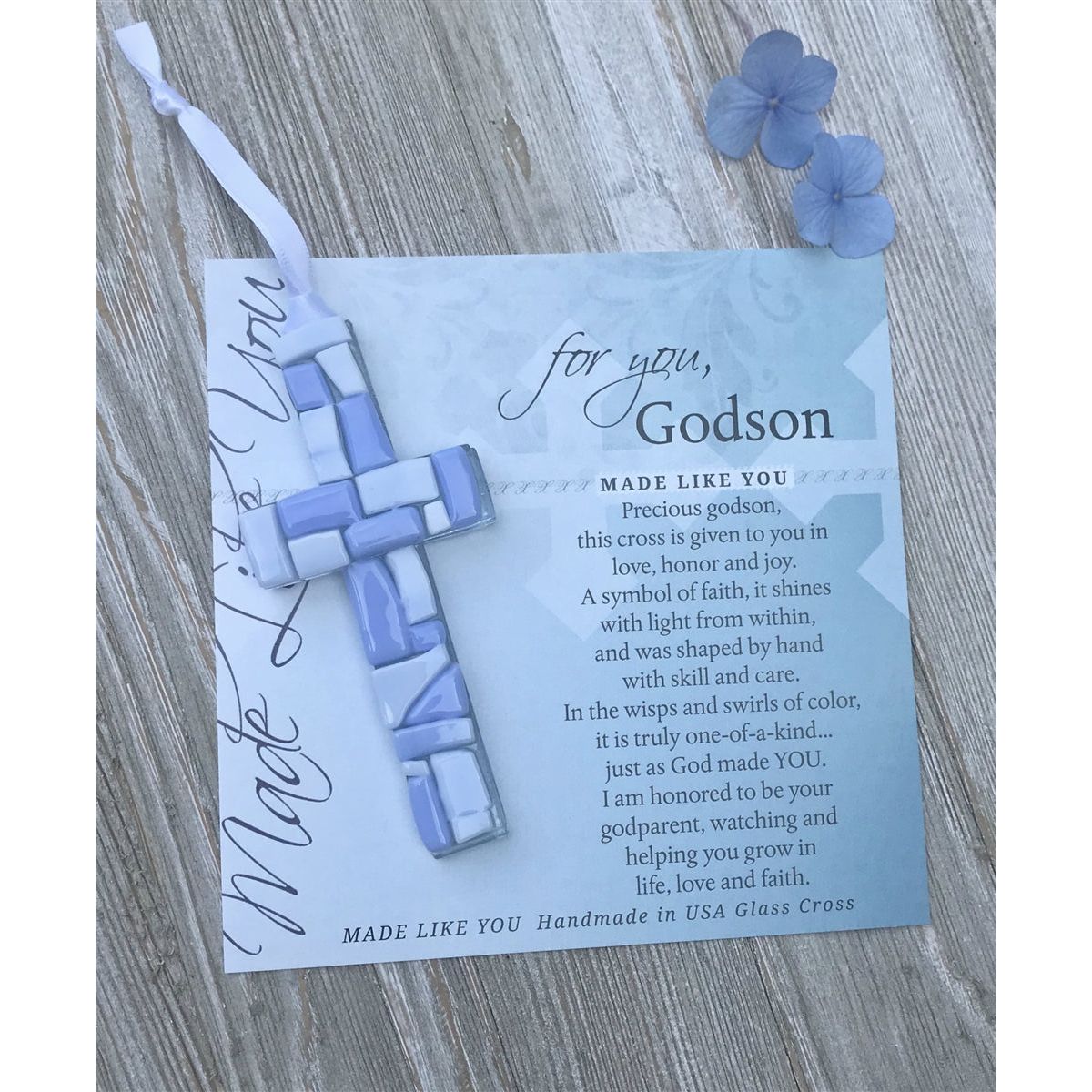 Blue Mosaic cross with shades of blue and white glass lying on the For You, Godson sentiment artwork.