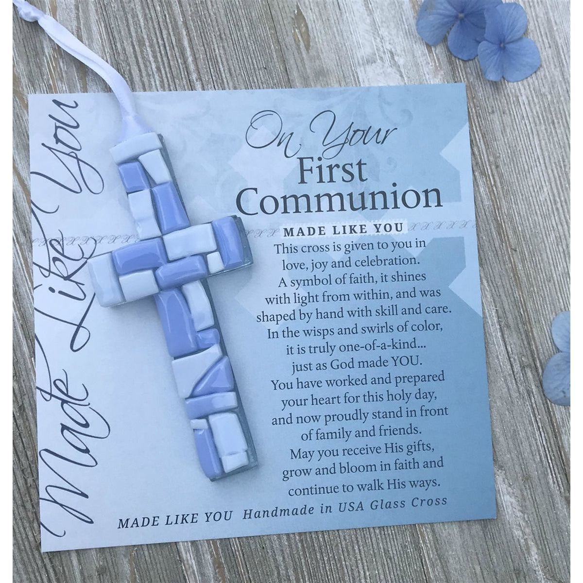 Blue Mosaic cross with shades of blue and white lying on the On Your First Communion sentiment artwork.