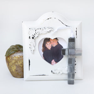 4 of 5:Gray glass mosaic cross in front of anniversary photo.