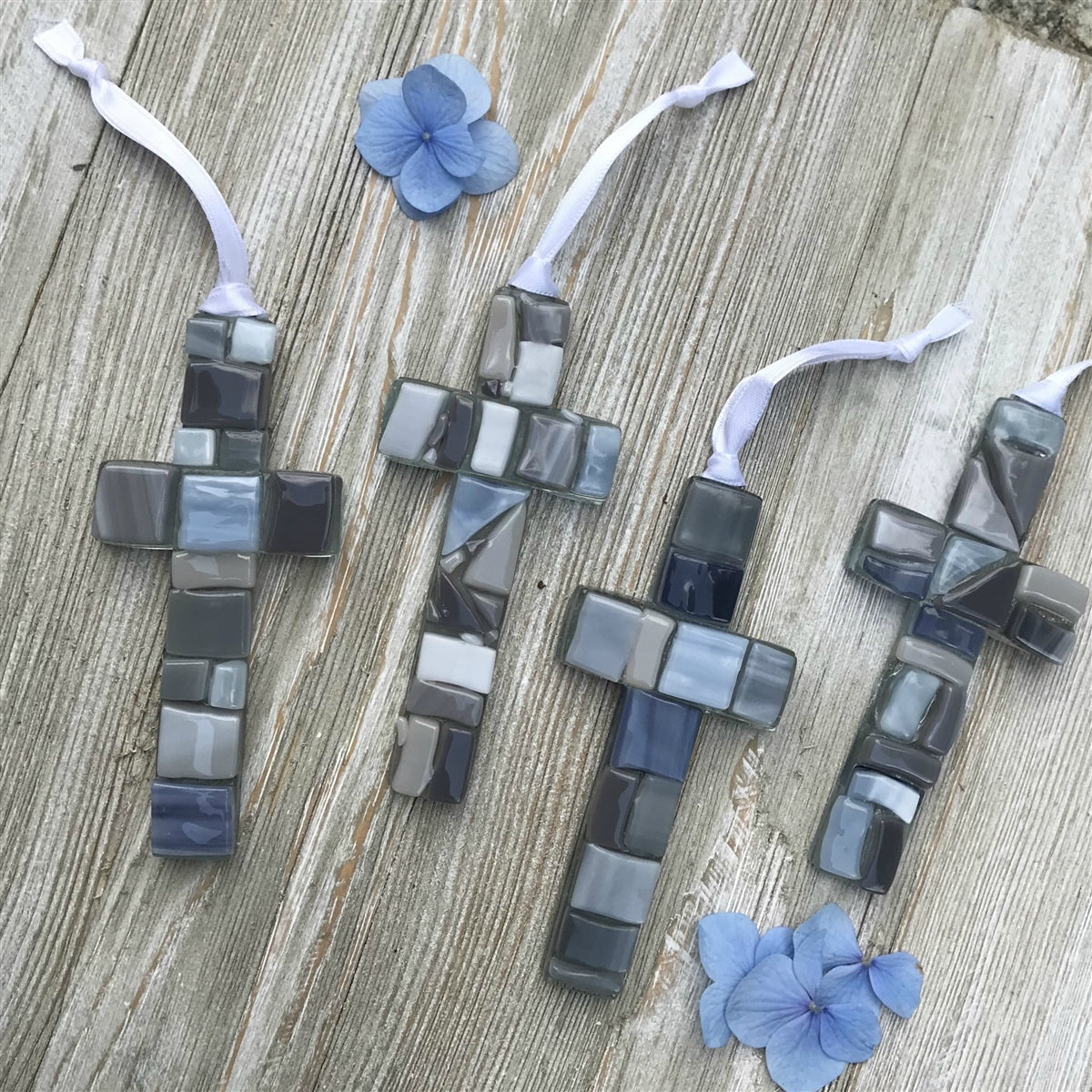 An assortment of gray mosaic crosses, each cross is unique.