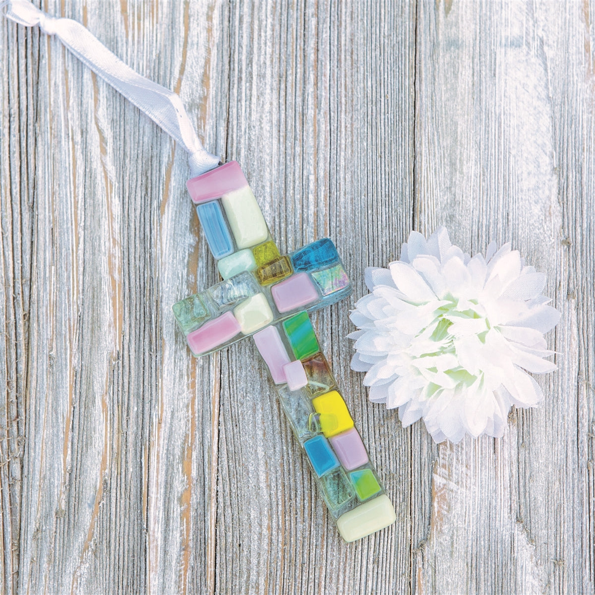 Pastel glass mosaic cross with white satin ribbon for hanging.