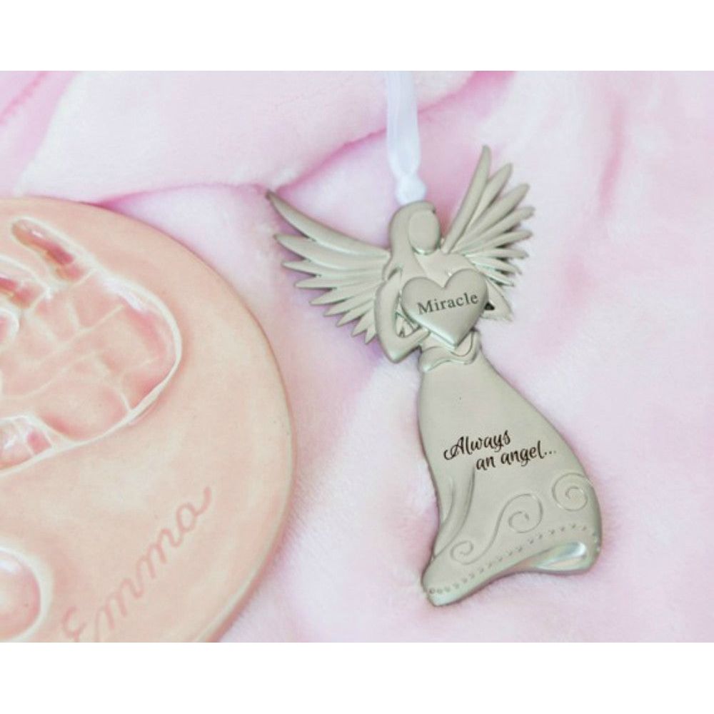 Silver toned metal angel holding a heart with the word "Miracle" and "Always an angel..." engraved in the skirt.