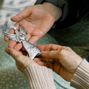 3 of 4:Miracle angel being exchanged between two hands.