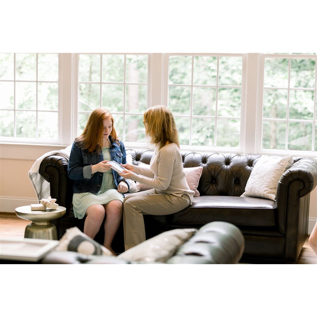 Two women exchanging a gift.