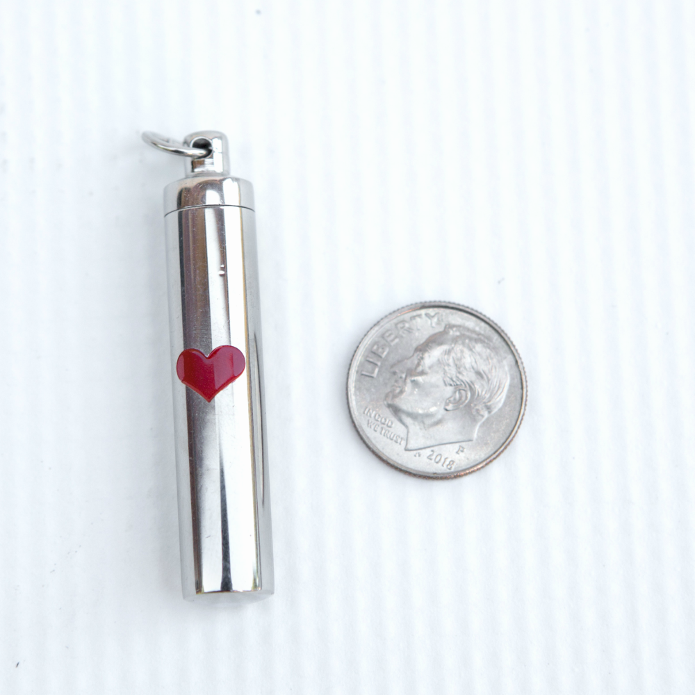 Ash vial next to a dime to show size.