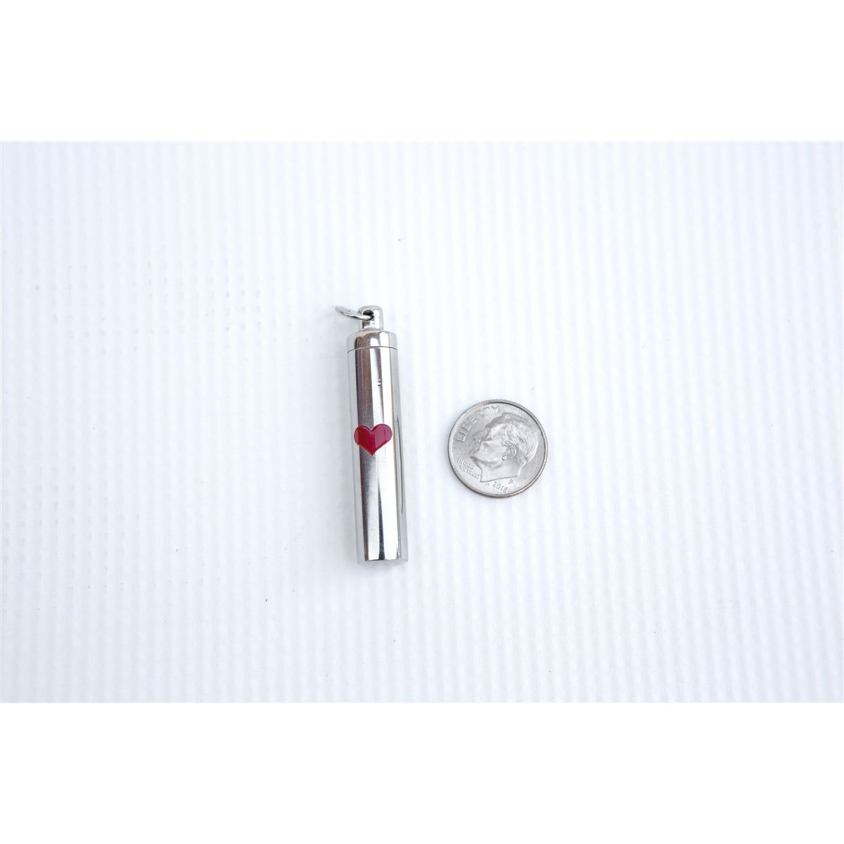 Ash vial next to a dime to show size.