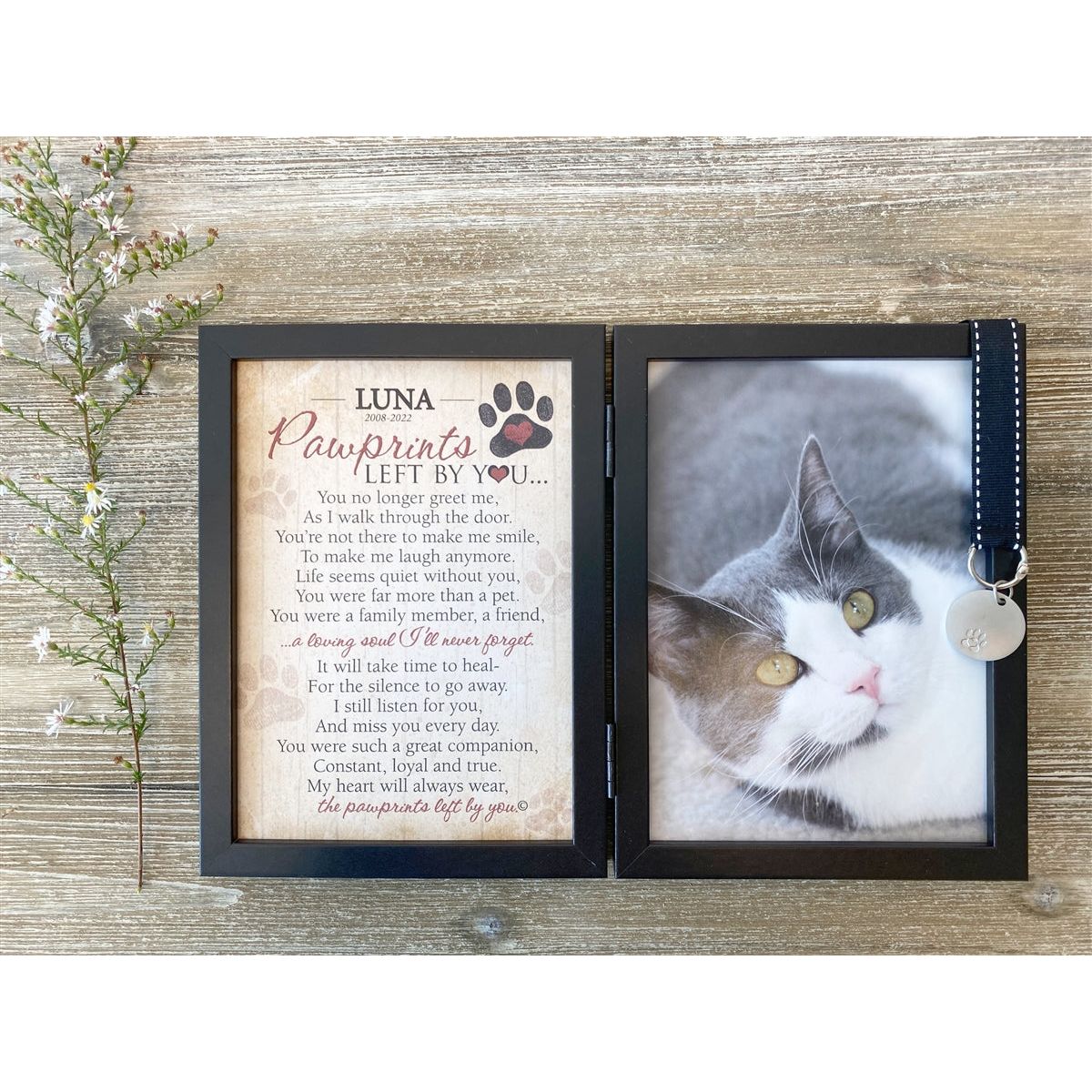 Frame features a black grosgrain ribbon with white stitching that holds a metal tag embossed with a pawprint.