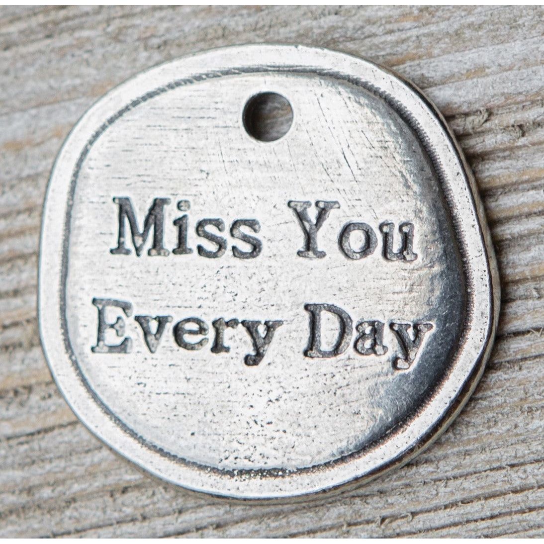 Detailed view of front of key chain and the words "Miss You Every Day".