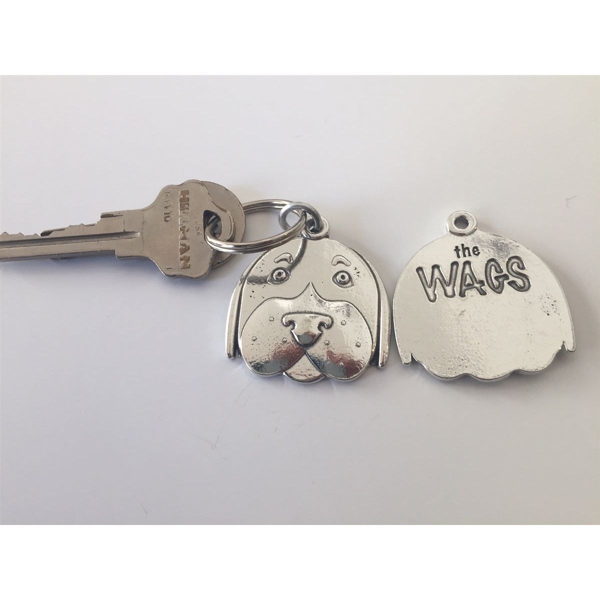 Pewter keychain with dog face on front and &quot;the WAGS&quot; on the back.